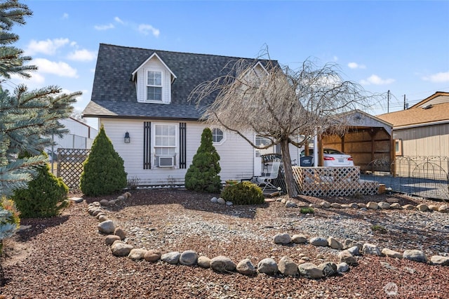 new england style home with fence and roof with shingles