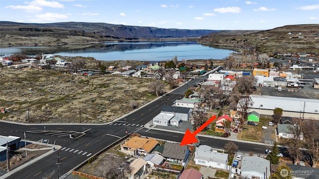 drone / aerial view featuring a water and mountain view