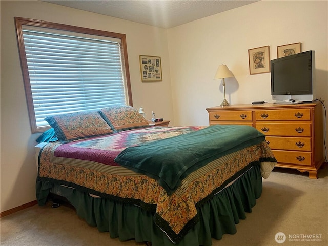 bedroom with light carpet and baseboards