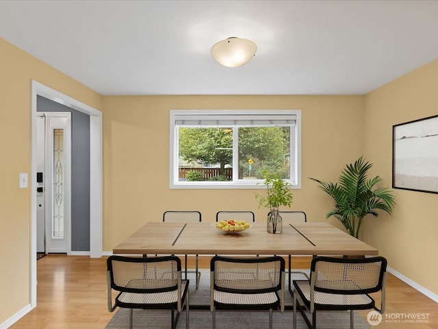 dining space featuring light wood-style floors and baseboards