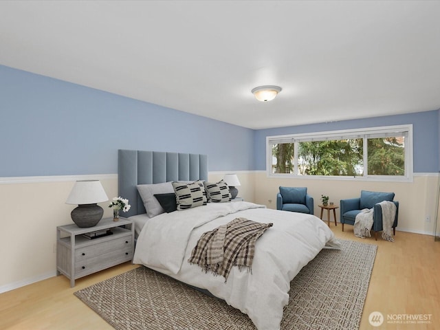 bedroom with light wood-type flooring and baseboards