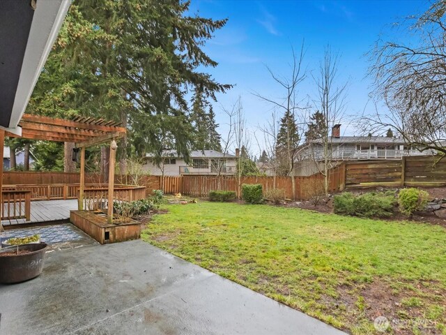 view of yard featuring a fenced backyard, a deck, a pergola, and a patio