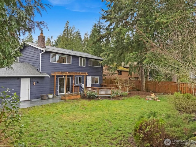 back of property featuring a yard, a chimney, fence, a deck, and a pergola