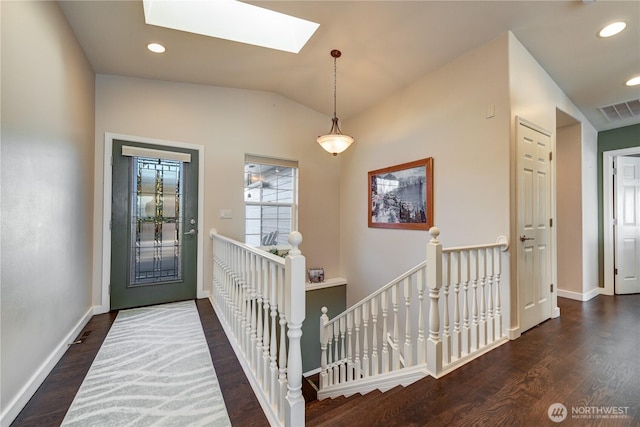 foyer entrance featuring recessed lighting, visible vents, wood finished floors, vaulted ceiling with skylight, and baseboards