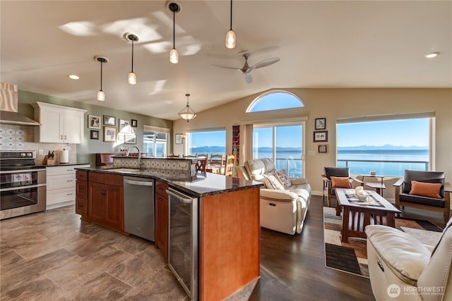 kitchen featuring stainless steel appliances, wine cooler, open floor plan, and lofted ceiling