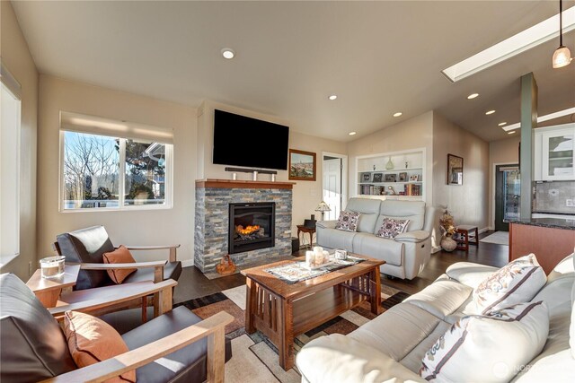 living area with lofted ceiling with skylight, recessed lighting, a fireplace, and light wood-style floors