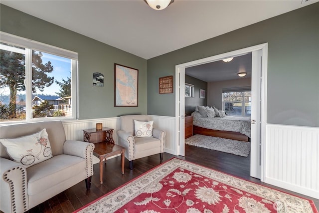 living area featuring wainscoting, radiator heating unit, and wood finished floors