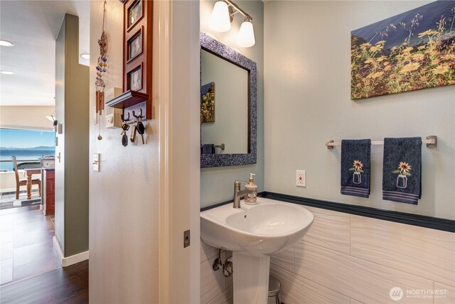 half bathroom featuring baseboards and wood finished floors