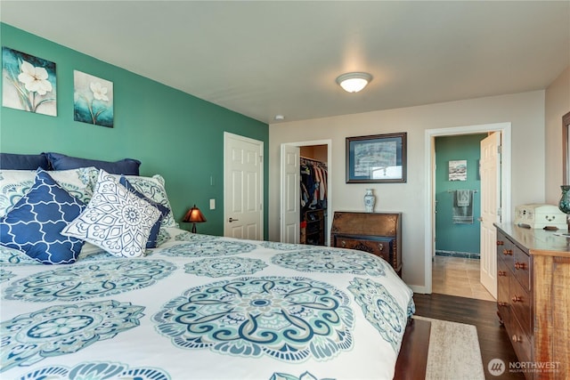 bedroom with dark wood-type flooring, a closet, connected bathroom, and a spacious closet