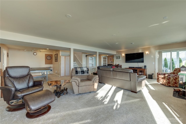 living area with carpet flooring and stairs