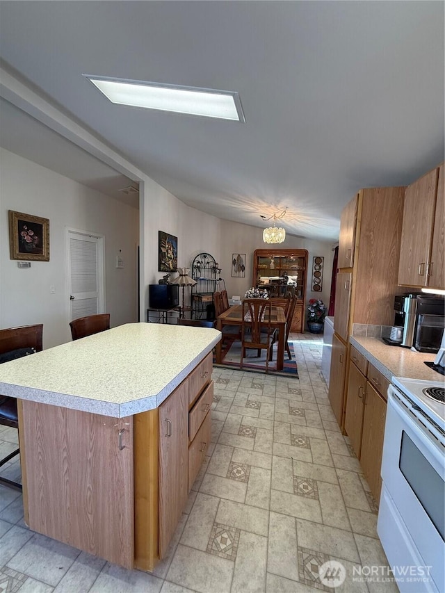 kitchen featuring brown cabinets, a kitchen island, light countertops, and electric stove