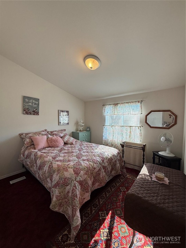 bedroom with visible vents and vaulted ceiling