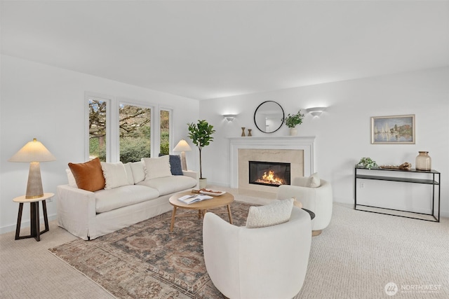 living room with carpet, a high end fireplace, and baseboards