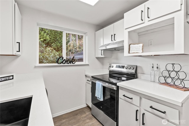 kitchen featuring light wood-style flooring, under cabinet range hood, white cabinets, light countertops, and stainless steel electric stove