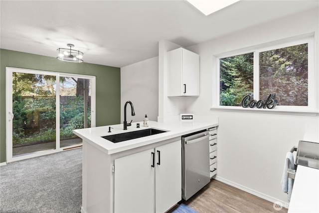 kitchen with stainless steel appliances, a healthy amount of sunlight, white cabinetry, a sink, and a peninsula