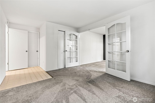 spare room featuring carpet floors and french doors