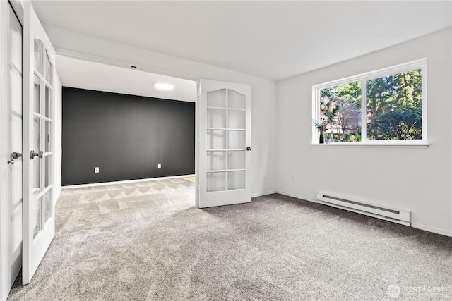 carpeted spare room with baseboards, baseboard heating, and french doors