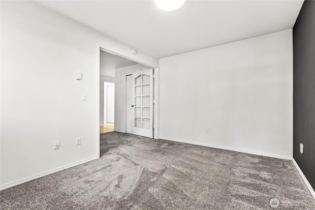 carpeted spare room featuring baseboards