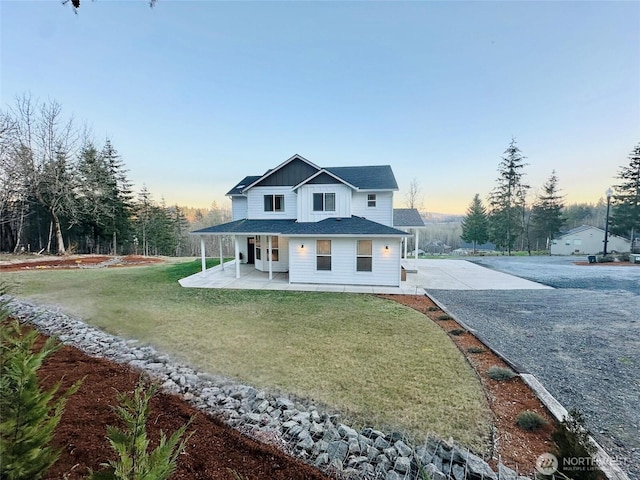 view of front of home with driveway, a front lawn, and board and batten siding