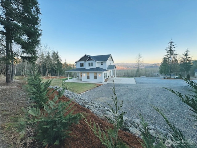 view of front of house featuring driveway and a patio