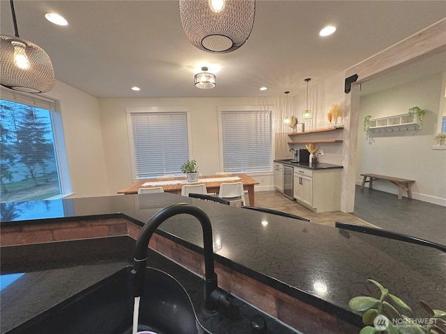 kitchen with baseboards, white cabinets, dark countertops, hanging light fixtures, and recessed lighting