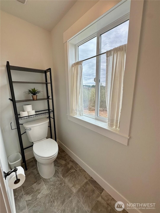 bathroom featuring toilet and baseboards