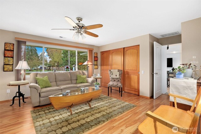 living area with ceiling fan, light wood finished floors, and visible vents