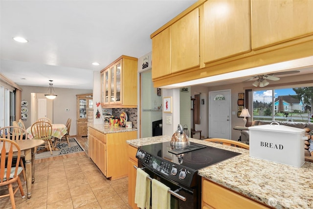 kitchen featuring black / electric stove, glass insert cabinets, a wealth of natural light, and tasteful backsplash