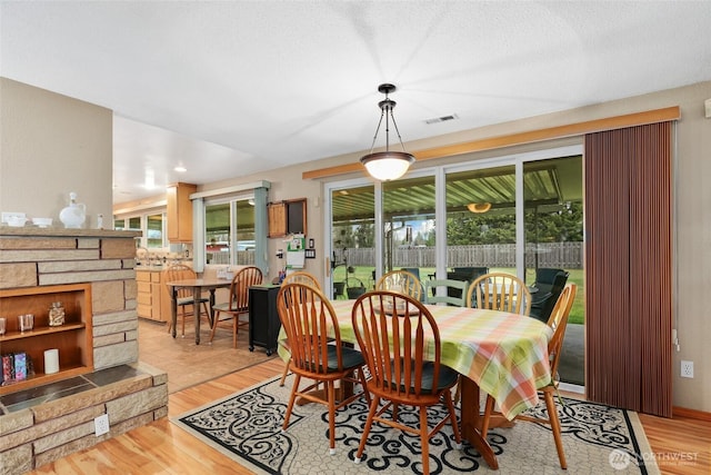 dining room with light wood-type flooring and visible vents