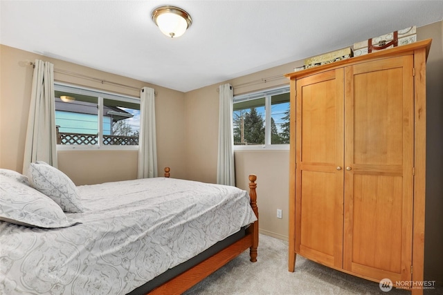 bedroom with light colored carpet and baseboards