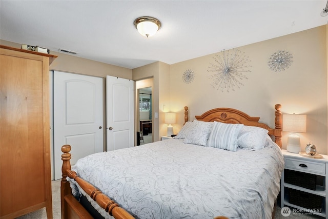 carpeted bedroom with a closet and visible vents