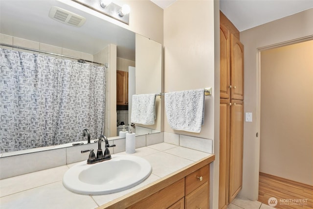 bathroom with a shower with shower curtain, vanity, and visible vents