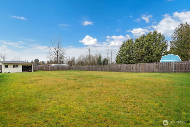 view of yard with fence, an outbuilding, and an outdoor structure