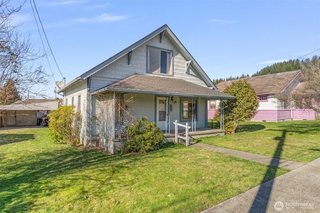 bungalow with covered porch, a front lawn, and roof with shingles