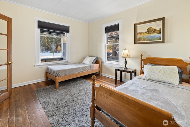 bedroom with wood-type flooring, baseboards, and crown molding