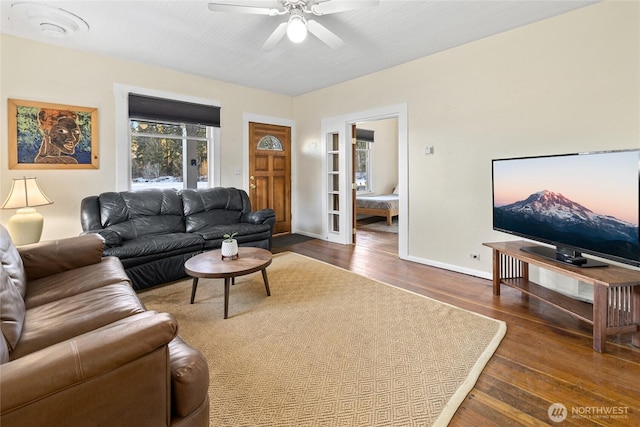 living area featuring wood-type flooring, baseboards, ceiling fan, and french doors