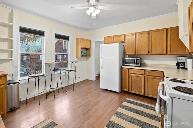 kitchen with light wood-style flooring, white appliances, a ceiling fan, light countertops, and crown molding