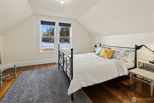 bedroom with vaulted ceiling, baseboards, and wood finished floors