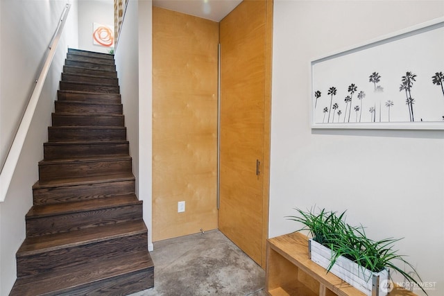 stairs featuring concrete flooring