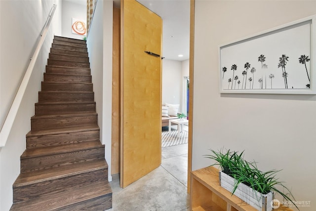 stairway with a barn door and concrete flooring