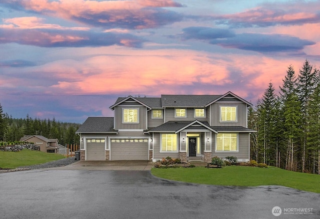 view of front of property featuring a garage, a lawn, stone siding, aphalt driveway, and board and batten siding