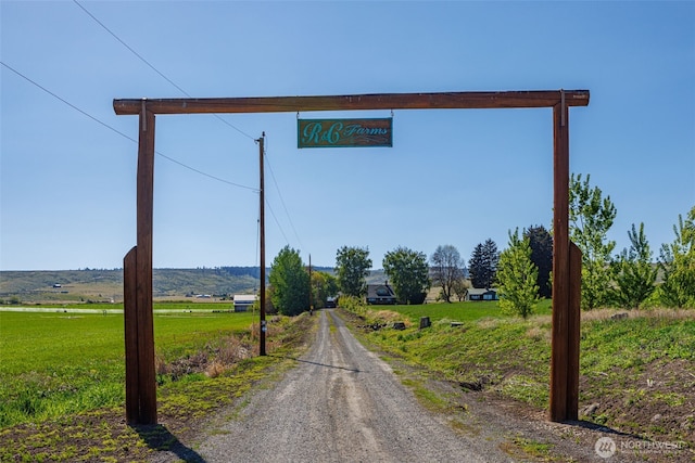 view of road featuring gravel driveway and a rural view