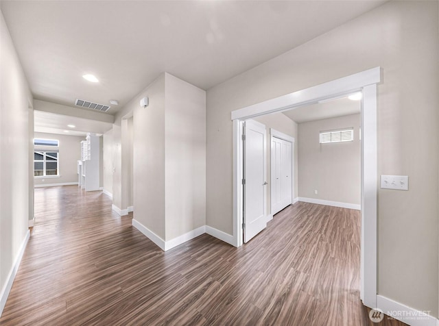 hallway featuring recessed lighting, dark wood finished floors, visible vents, and baseboards