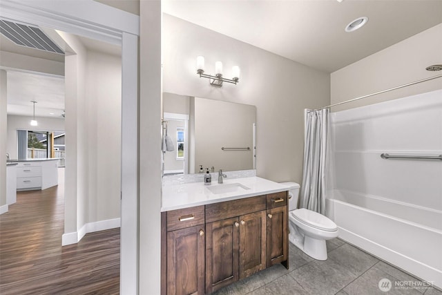 bathroom with visible vents, toilet, shower / bath combo, vanity, and baseboards