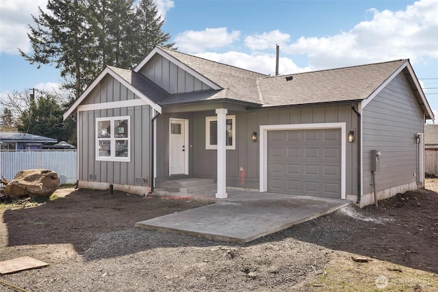 ranch-style home with board and batten siding, a shingled roof, fence, a garage, and driveway