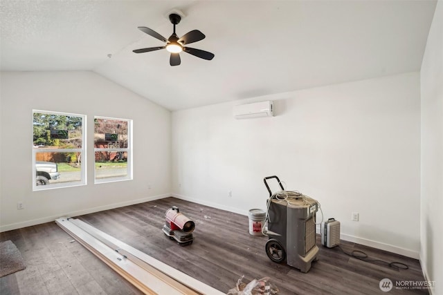 interior space featuring baseboards, wood finished floors, vaulted ceiling, and a wall unit AC