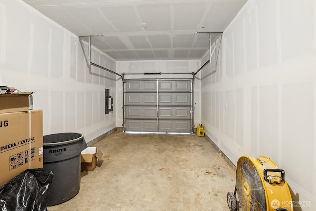 garage featuring electric panel and baseboards