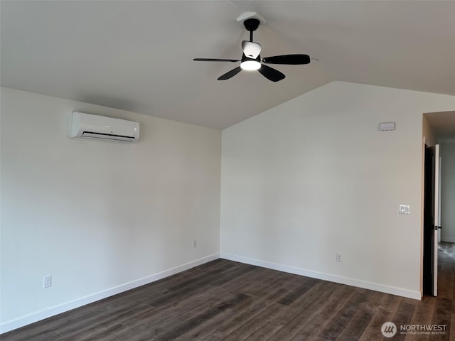 empty room featuring lofted ceiling, an AC wall unit, dark wood-type flooring, and baseboards