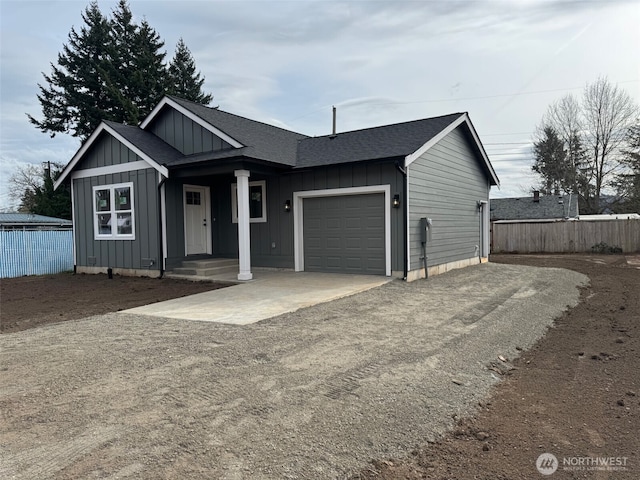 single story home with driveway, fence, board and batten siding, an attached garage, and a shingled roof