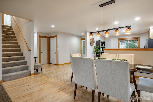 dining area with light wood-style flooring, stairway, baseboards, and recessed lighting